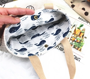 Détail intérieur du sac en velours avec doublure baleine et fermeture par bouton-pression