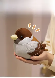 Close-up of a small, soft sparrow plush toy being held in hands, showing realistic details