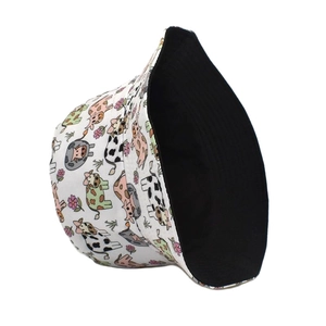 Detailed view of reversible cow print bucket hat with cartoon patterns and black inner lining
