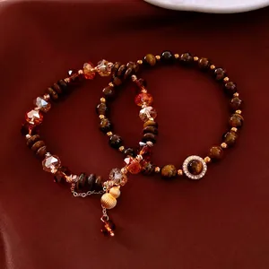 Bracelet en perles d'oeil de tigre avec pendentif gourde dorée sur fond de soie