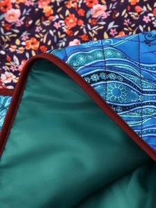 Detail of floral patchwork cotton jacket featuring quilted textures and multi-color stitching
