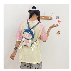 Cute cartoon shark-cat plush backpack worn by a model in a minimal indoor setting