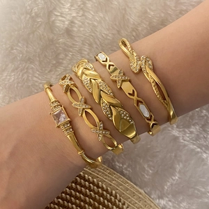 Set di cinque bracciali dorati con cristalli scintillanti e raffinati motivi intrecciati
