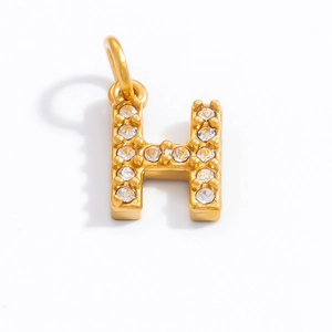 Close-up of golden letter H pendant with sparkling white rhinestones and polished finish