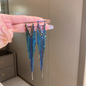 Detailed close-up of blue and black gradient tassel earrings with shimmering rhinestones