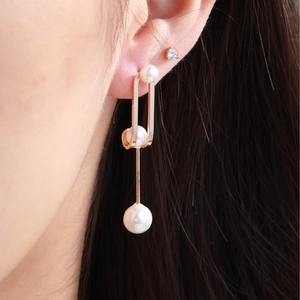 Elegant rose gold drop earrings with graduated pearls on a model for a luxury look