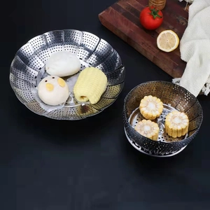 Close-up of foldable stainless steel steamer basket with corn and steamed buns