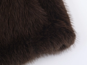 Detailed macro shot of dark brown faux fur texture with high-density long plush fibers