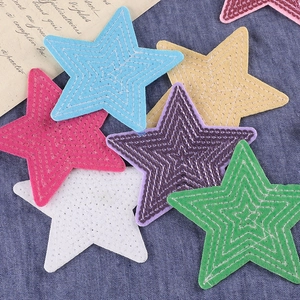 Glitter sequin star embroidery patches in various colors on blue denim background