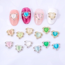 Detail of alloy heart nail charms with cat eye stones and rhinestones in various colors