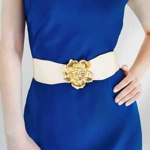 Ceinture élastique crème avec grande boucle fleurie dorée sur une robe bleue élégante