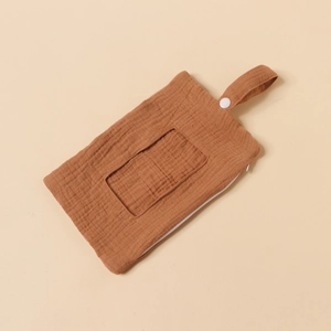 Detail view of terracotta muslin cotton baby storage bag with zipper and snap strap