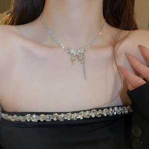 Close-up of sparkling butterfly tassel necklace with rhinestones on a woman's neck