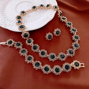 Golden flower jewelry set with dark green gemstones and sparkling crystals for women