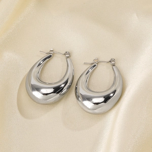 Polished silver stainless steel U-shaped oval earrings on a soft silk fabric background