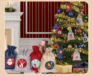 Close-up of linen Christmas countdown drawstring bags with reindeer and snowman prints