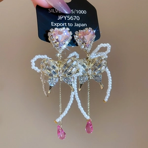 Detail of butterfly earring with pink heart crystal, pearls and silver 925 needle
