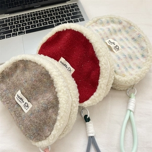 Detailed view of plush shell-shaped cosmetic bags with lamb wool trim and braided rope straps