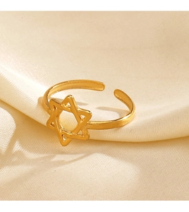Macro detail of golden open ring with hollow hexagram star design on silk background