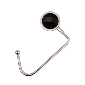 Detail of portable silver metal bag hook with a multifaceted black diamond crystal inlay
