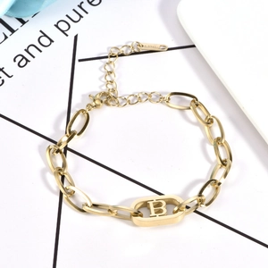 Close-up of golden stainless steel chain bracelet with a capital B letter pendant
