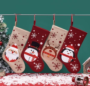 Nahaufnahme von vier festlichen Weihnachtssocken mit Nikolaus, Schneemann, Rentier und Pinguin