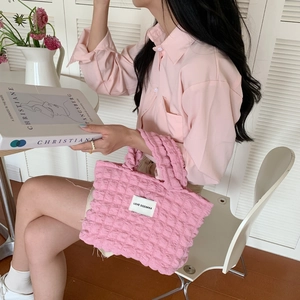 Pink quilted bubble texture canvas handbag for women in a minimalist lifestyle setting