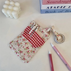 Close-up of floral and plaid multi-pocket nurse pouch organizer for pens and stationery