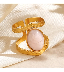 Detail of 18K gold plated oval ring with pink stone on beige satin fabric