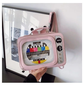 Detail of pink retro TV crossbody bag featuring clear screen window and heart rivet accent