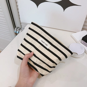 Handheld striped cotton makeup pouch with simple wish label on white background