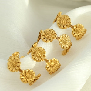 Retro 18k gold sunflower rings with realistic petal texture on a white background