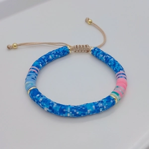 Detail of colorful Heishi bead bracelet with gold accents and adjustable cord