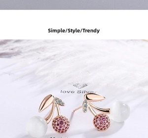 Macro shot of rose gold cherry stud earrings with opal beads and pavé purple crystals
