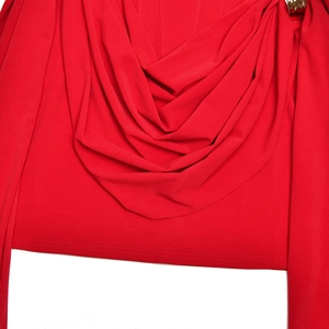 Close-up of elegant red dress featuring smooth matte fabric with draped pleats and side slit