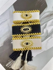 Nahaufnahme der handgewebten Evil Eye Armbänder mit Goldperlen und Quasten