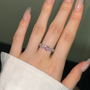 Close-up of S925 silver ring featuring a pink heart-shaped gemstone on a model's finger