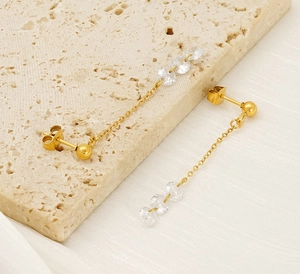 Detail von 18k vergoldeten Edelstahl-Ohrhängern mit funkelnden Zirkonia in einer Nahaufnahme