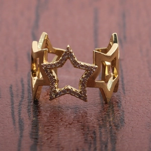Macro view of gold-plated star ring with sparkling cubic zirconia on a wooden background