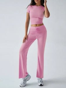 Pink rib-knit two-piece set featuring short sleeve crop top and drawstring flare pants