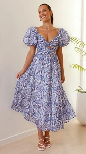 Detail eines blau geblümten Maxikleides mit Puffärmeln und Cut-out-Knotendetail