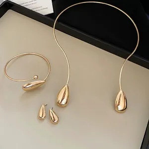 Minimalist gold teardrop jewelry set including polished neck ring, bracelet and earrings
