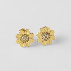 Détail de boucles d'oreilles tournesol dorées avec zircons et pétales finement gravés