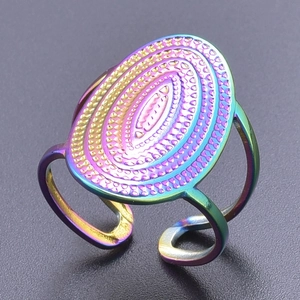 Macro shot of colorful stainless steel ring featuring oval texture and open adjustable band