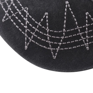 Macro shot of complex gray zigzag embroidery on black washed cotton baseball cap fabric