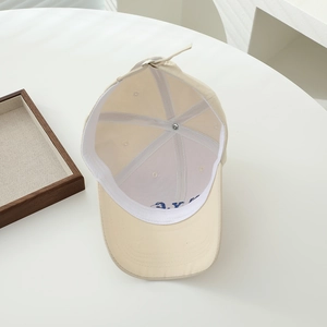Detail view of the cotton baseball cap's internal stitching and blue embroidered letters