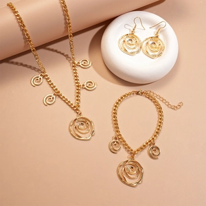 Golden rose jewelry set with hollow flower necklace, bracelet and earrings on stone tray