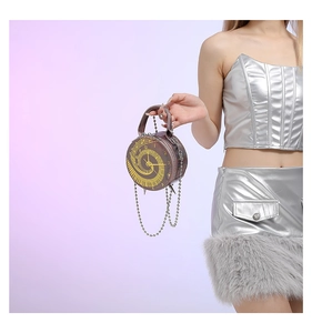 Detailed view of brown clock-shaped handbag with Roman numerals and metal chain strap