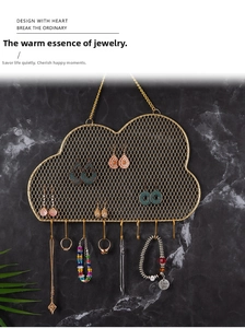 Detail showing the cloud-shaped iron mesh and bottom hooks of the golden jewelry holder