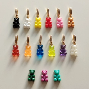 Flat lay of colorful resin gummy bear charms with crystal embedded metal clasps